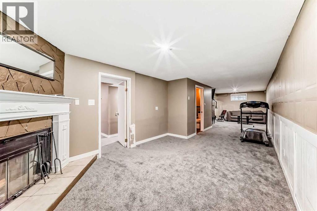 707 Malvern Drive Ne, Calgary, AB - Indoor Photo Showing Other Room With Fireplace