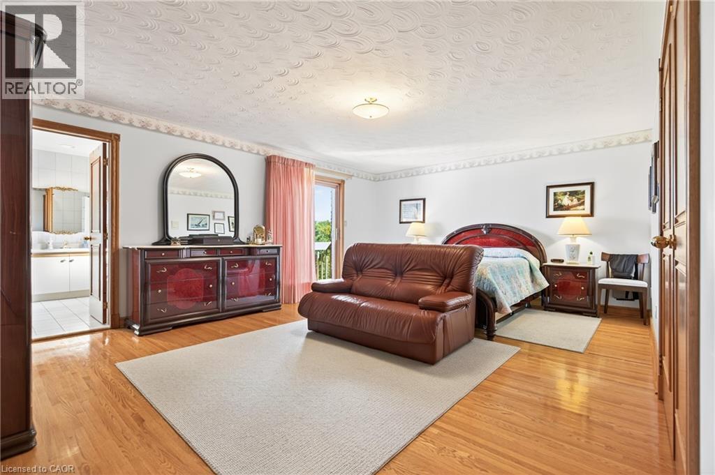 Bedroom with a textured ceiling, light wood finished floors, and access to exterior - 79 Maple Drive, Hamilton, ON - Indoor