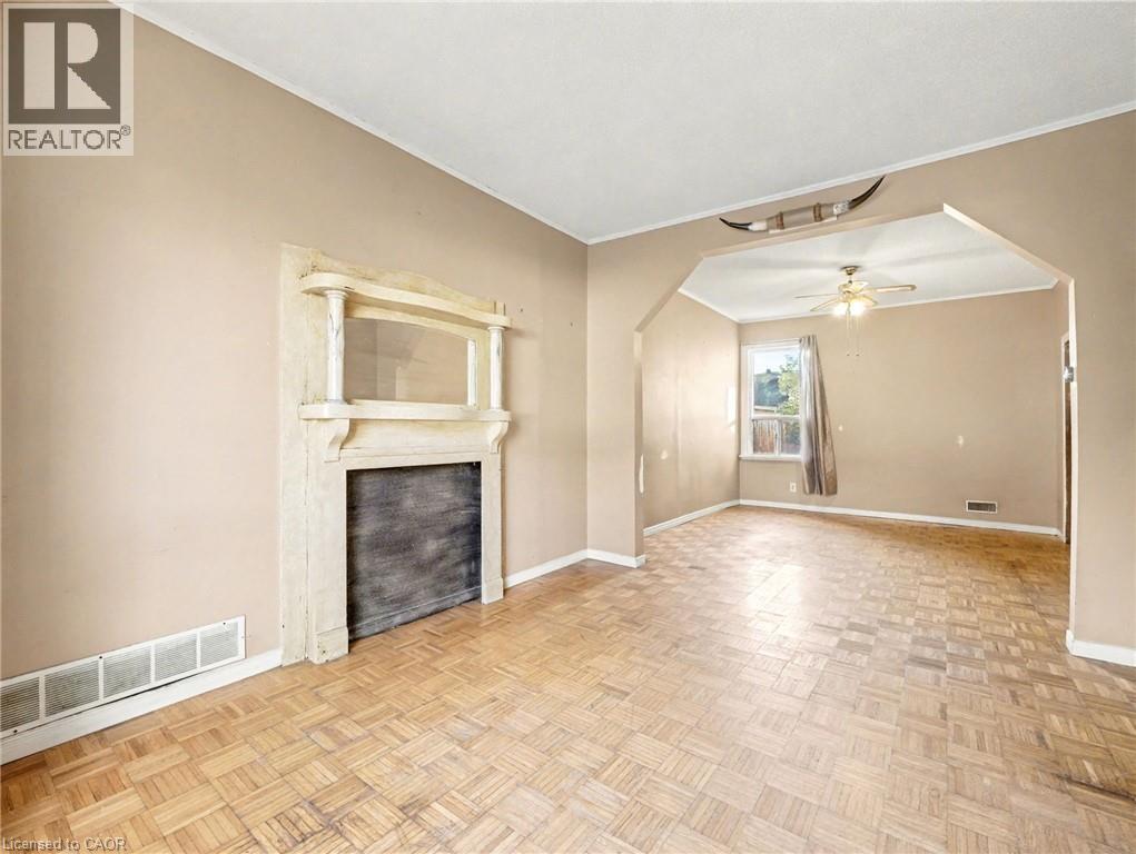 Unfurnished living room with arched walkways, ornamental molding, and a ceiling fan - 23 Oak Avenue, Hamilton, ON - Indoor Photo Showing Other Room With Fireplace