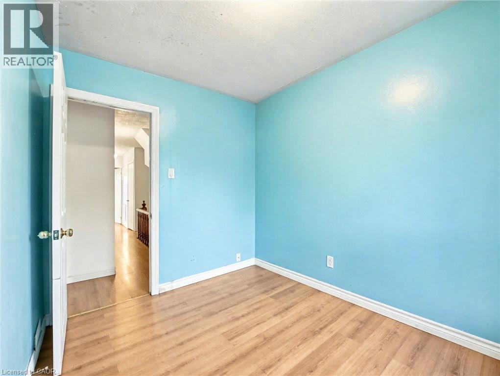 Spare room featuring wood finished floors and a textured ceiling - 23 Oak Avenue, Hamilton, ON - Indoor Photo Showing Other Room