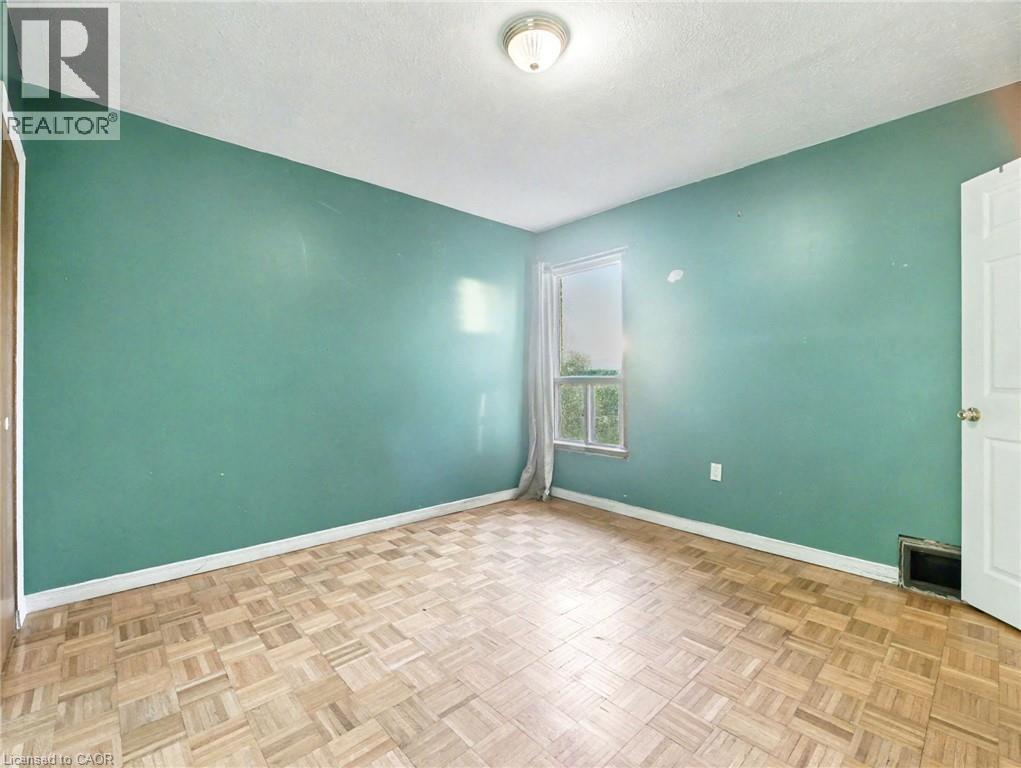 Unfurnished room featuring a textured ceiling and baseboards - 23 Oak Avenue, Hamilton, ON - Indoor Photo Showing Other Room