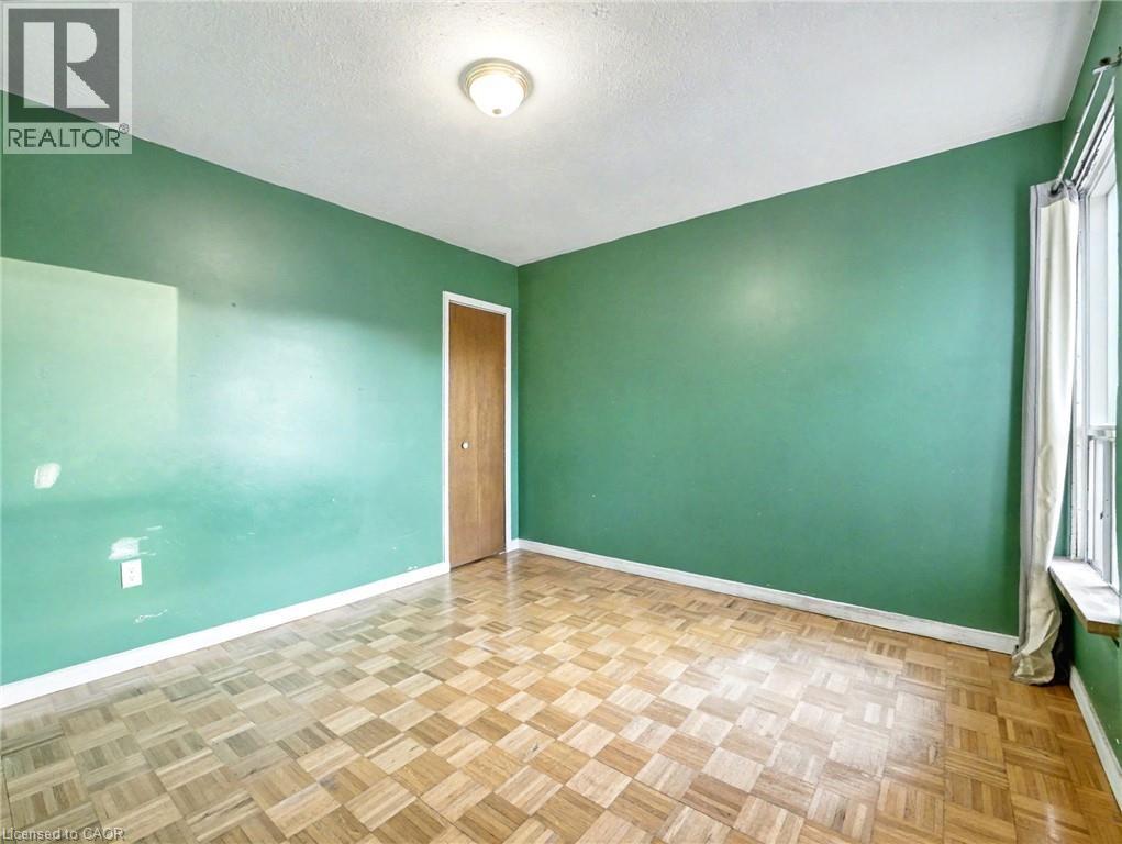 Spare room featuring a textured ceiling and baseboards - 23 Oak Avenue, Hamilton, ON - Indoor Photo Showing Other Room