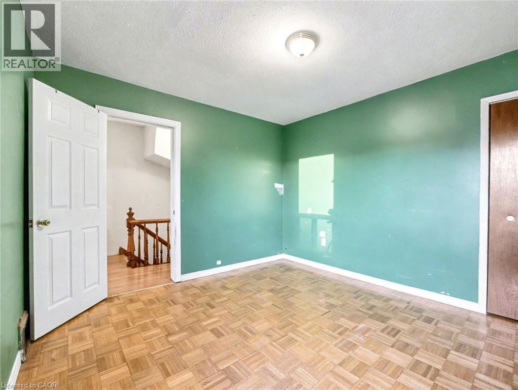 Spare room featuring a textured ceiling and baseboards - 23 Oak Avenue, Hamilton, ON - Indoor Photo Showing Other Room