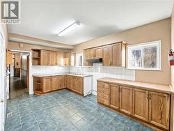 Kitchen featuring open shelves, backsplash, brown cabinets, and healthy amount of natural light -
