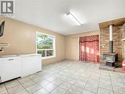 Unfurnished living room with a wood stove and light tile patterned floors -
