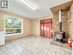 Unfurnished living room with a wood stove and light tile patterned floors -