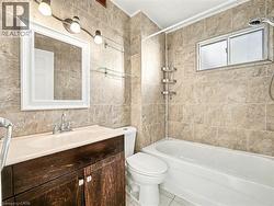 Bathroom with tile walls, shower / bathtub combination, vanity, and tile patterned flooring -