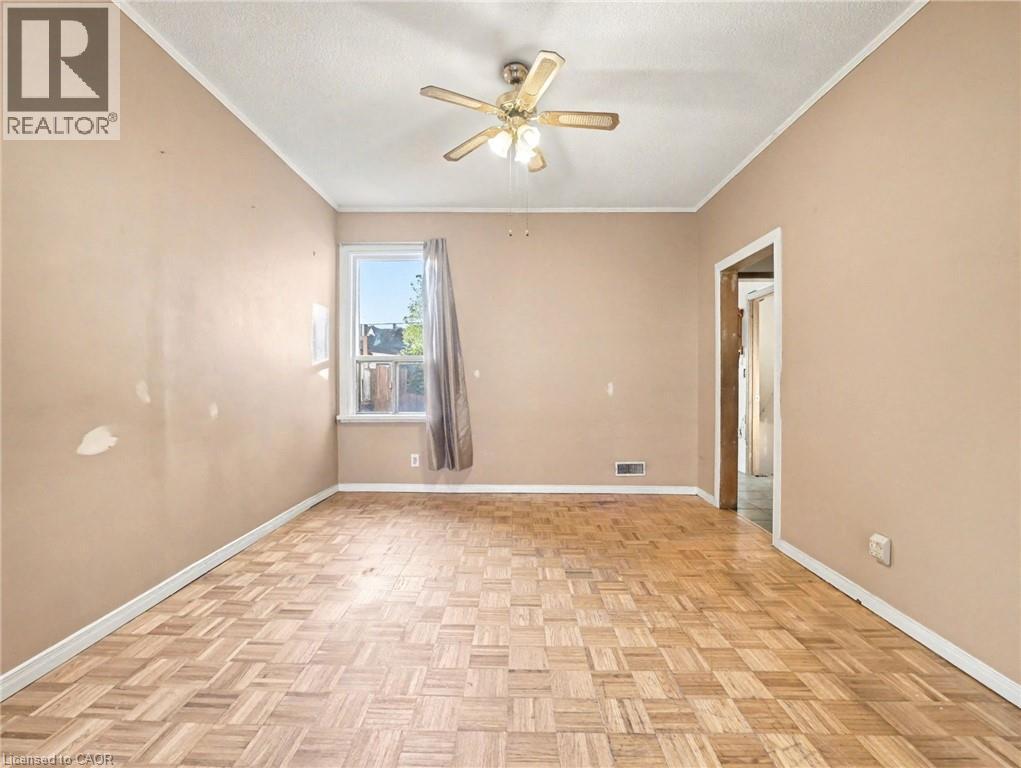 Empty room featuring crown molding, a textured ceiling, and a ceiling fan - 23 Oak Avenue, Hamilton, ON - Indoor Photo Showing Other Room