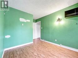 Empty room featuring a textured ceiling and wood finished floors -