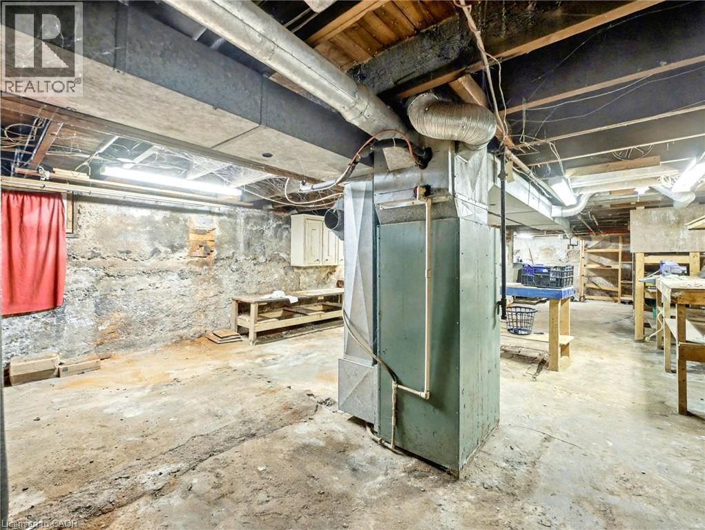 Unfinished basement with heating unit - 23 Oak Avenue, Hamilton, ON - Indoor Photo Showing Basement