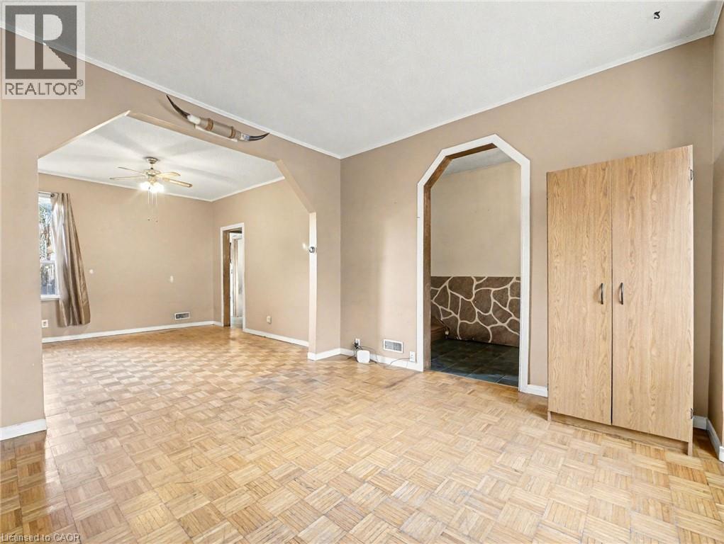 Empty room featuring ornamental molding, arched walkways, and a ceiling fan - 23 Oak Avenue, Hamilton, ON - Indoor Photo Showing Other Room