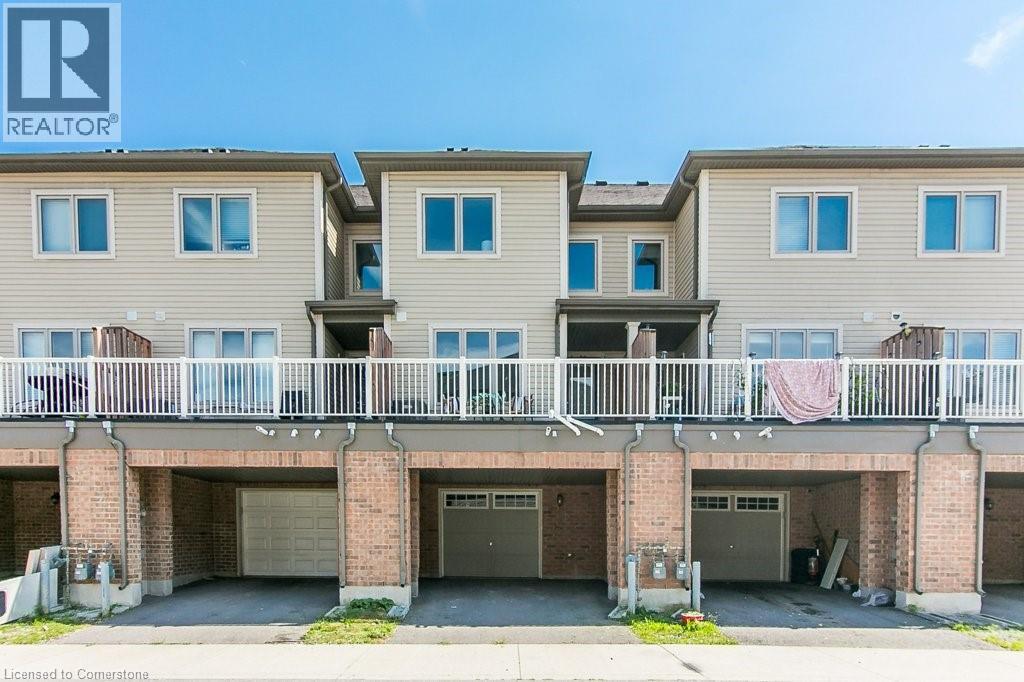 Rear view of house featuring brick siding, a garage, and driveway - 386 Linden Drive, Cambridge, ON - Outdoor With Balcony With Deck Patio Veranda