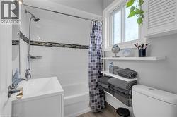 Bathroom featuring shower / tub combo, light wood finished floors, and vanity -