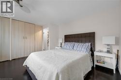 Bedroom featuring dark wood finished floors, ceiling fan, and two closets -