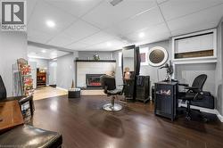 Home office with a paneled ceiling, wood finished floors, a fireplace, and recessed lighting -
