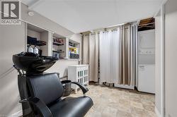 Home office with stacked washer / drying machine and stone finish floors -