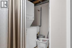 Laundry room featuring stacked washing machine and dryer -