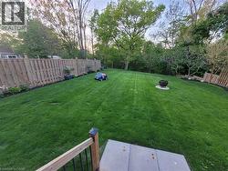 Fenced backyard featuring view of scattered trees -