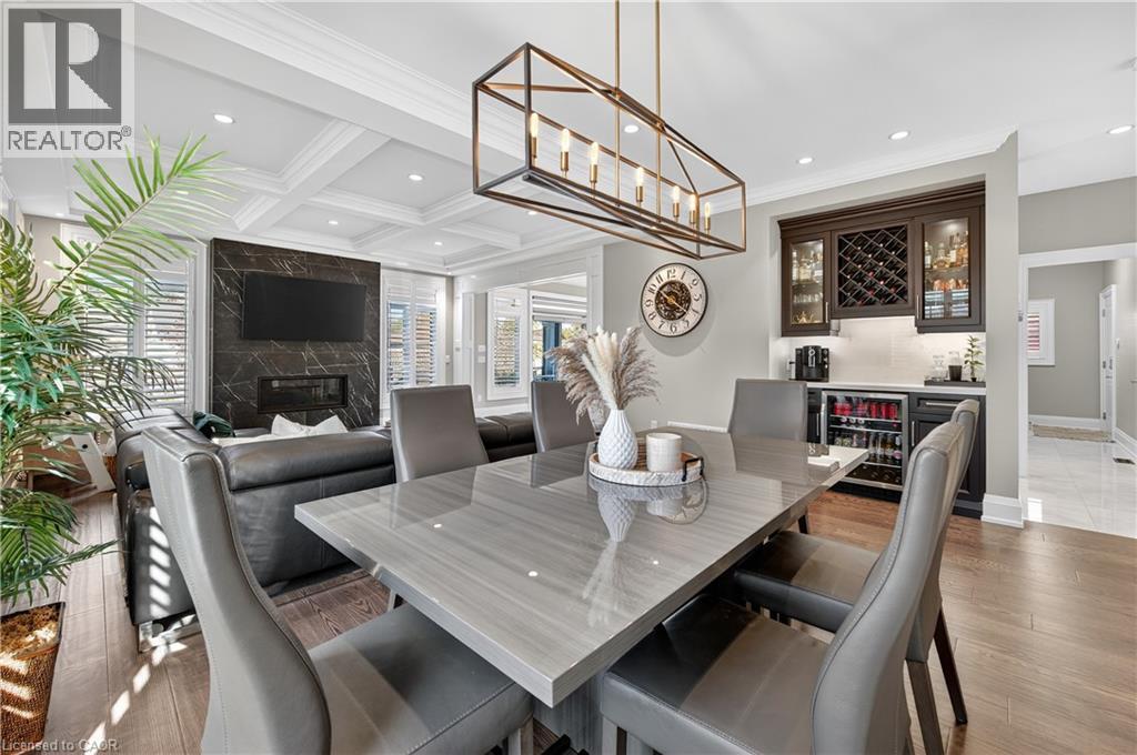 Dining room featuring a bar, recessed lighting, a high end fireplace, beamed ceiling, and beverage cooler - 18 David Avenue, Hamilton, ON - Indoor Photo Showing Dining Room With Fireplace