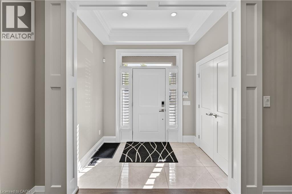 Foyer featuring light tile patterned floors, ornamental molding, and a tray ceiling - 18 David Avenue, Hamilton, ON - Indoor Photo Showing Other Room