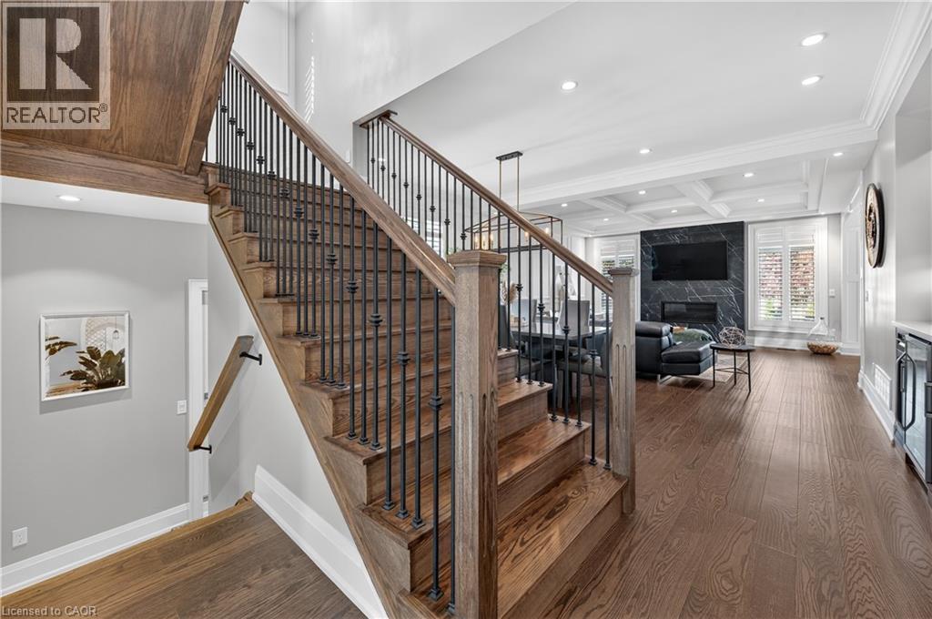 Staircase featuring wood finished floors, a fireplace, recessed lighting, beamed ceiling, and coffered ceiling - 18 David Avenue, Hamilton, ON - Indoor Photo Showing Other Room