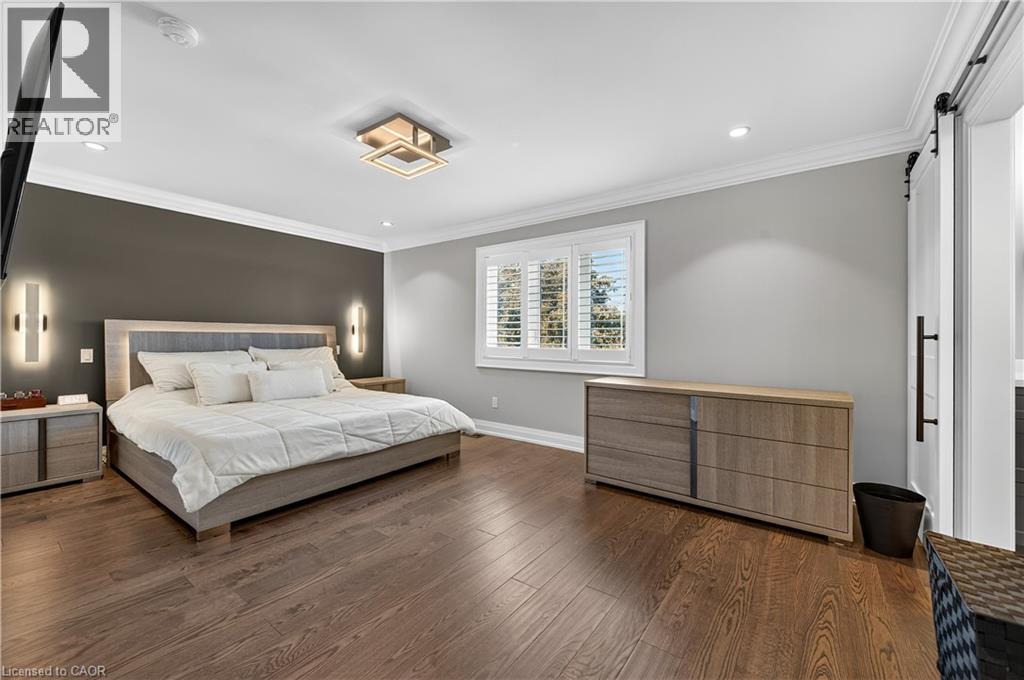 Bedroom with ornamental molding, a barn door, dark wood-style floors, and recessed lighting - 18 David Avenue, Hamilton, ON - Indoor Photo Showing Bedroom