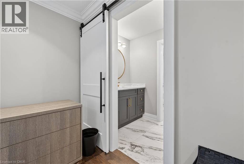 Bathroom featuring vanity, crown molding, and dark marble finish floors - 18 David Avenue, Hamilton, ON - Indoor Photo Showing Other Room