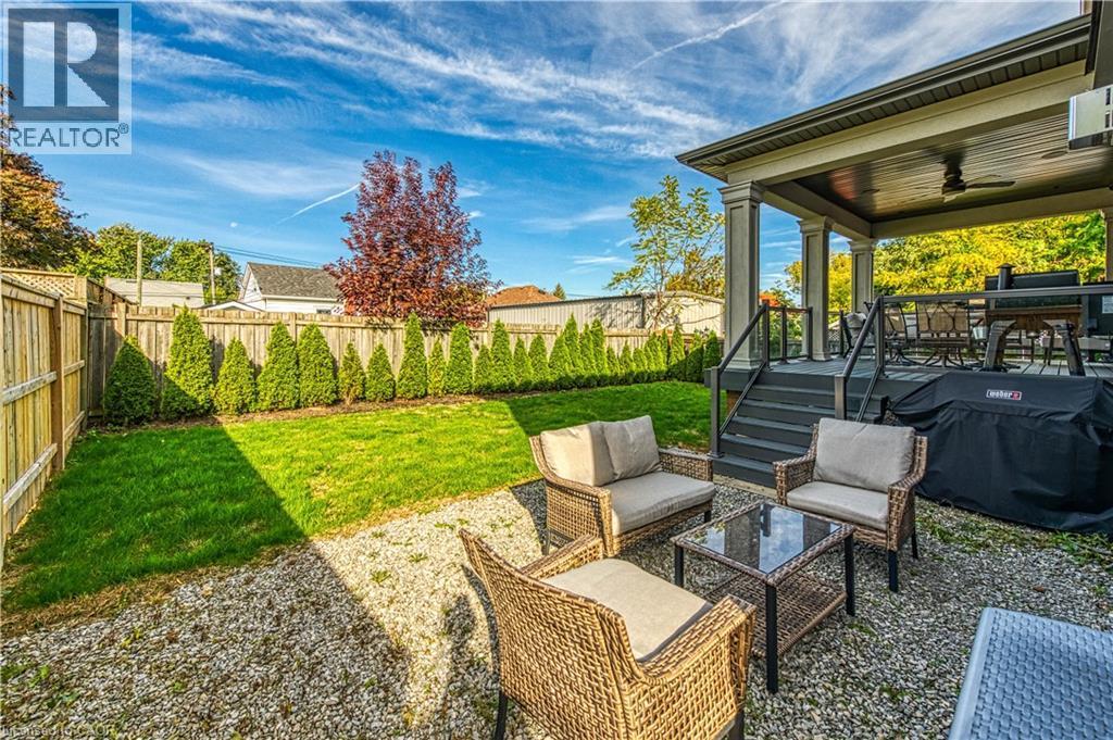 Fenced backyard featuring a patio area, a ceiling fan, an outdoor hangout area, grilling area, and a wooden deck - 18 David Avenue, Hamilton, ON - Outdoor With Deck Patio Veranda