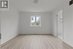 Unfurnished room featuring light wood finished floors and baseboards -