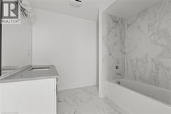 Bathroom featuring vanity, light marble finish floors, and shower / bath combination -