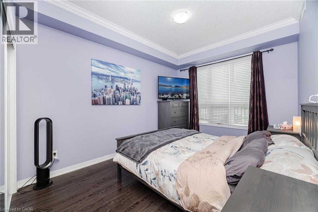 Bedroom with crown molding and wood finished floors - 5317 Upper Middle Road Unit# 112, Burlington, ON - Indoor Photo Showing Bedroom