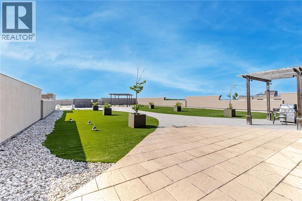 View of property's community featuring a pergola, a fenced backyard, and a patio area - 5317 Upper Middle Road Unit# 112, Burlington, ON - Outdoor