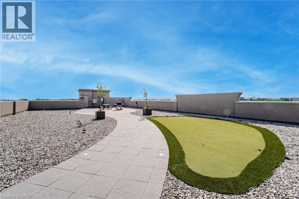 View of property's community with an area to practice putting and a fenced backyard - 5317 Upper Middle Road Unit# 112, Burlington, ON - Outdoor