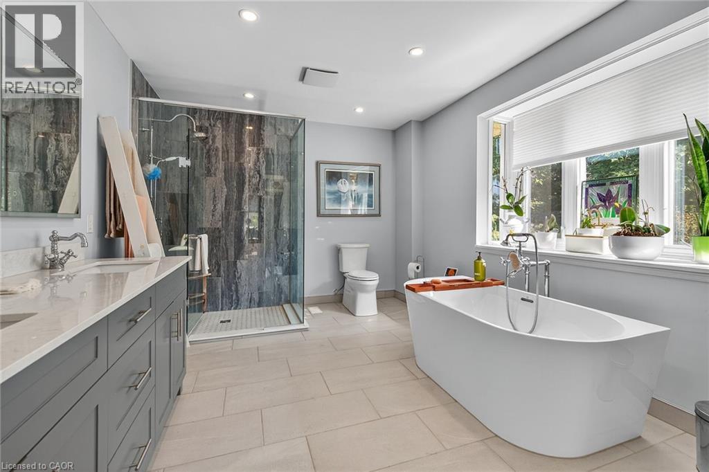 Bathroom with double vanity, a freestanding tub, a stall shower, light tile patterned floors, and recessed lighting - 5590 Blind Line, Burlington, ON - Indoor Photo Showing Bathroom