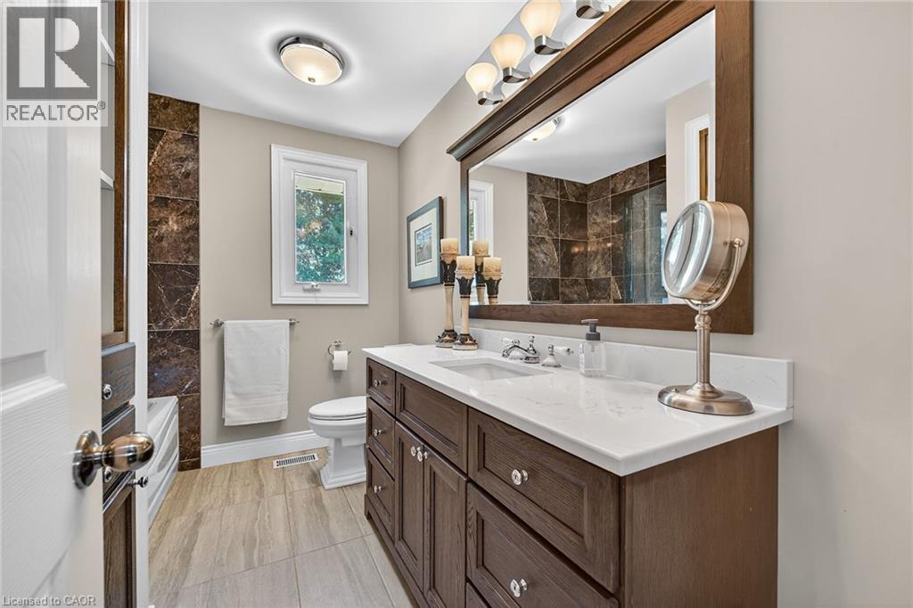 Full bathroom featuring vanity, bathtub / shower combination, and light tile patterned floors - 5590 Blind Line, Burlington, ON - Indoor Photo Showing Bathroom