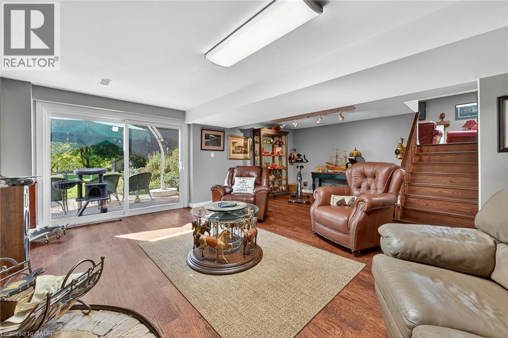 Living area with wood finished floors, stairs, and track lighting - 5590 Blind Line, Burlington, ON - Indoor Photo Showing Living Room