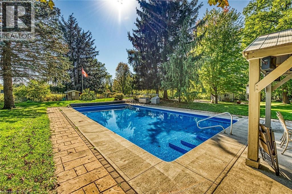 Outdoor pool featuring a lawn, a patio area, and a storage shed - 5590 Blind Line, Burlington, ON - Outdoor With In Ground Pool With Backyard