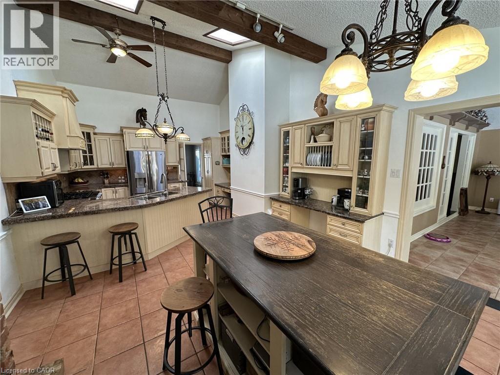 Dining space featuring a chandelier, light tile patterned flooring, a ceiling fan, high vaulted ceiling, and track lighting - 5590 Blind Line, Burlington, ON - Indoor Photo Showing Dining Room