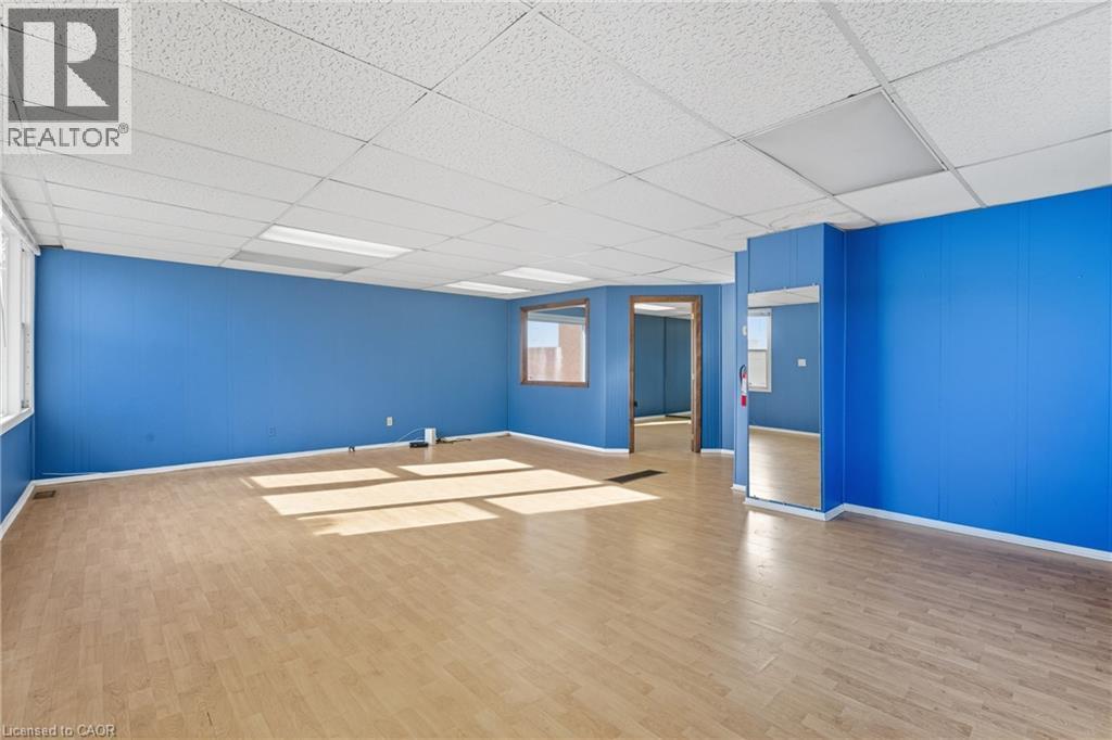 Empty room featuring wood finished floors and a paneled ceiling - 1036 Upper Wentworth Street, Hamilton, ON