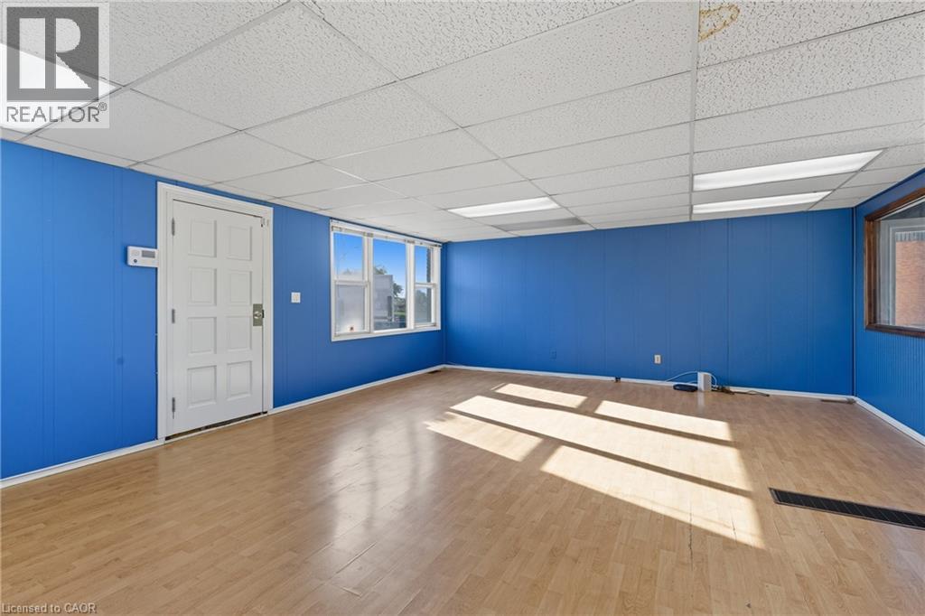 Empty room with wood finished floors, a drop ceiling, and wood walls - 1036 Upper Wentworth Street, Hamilton, ON