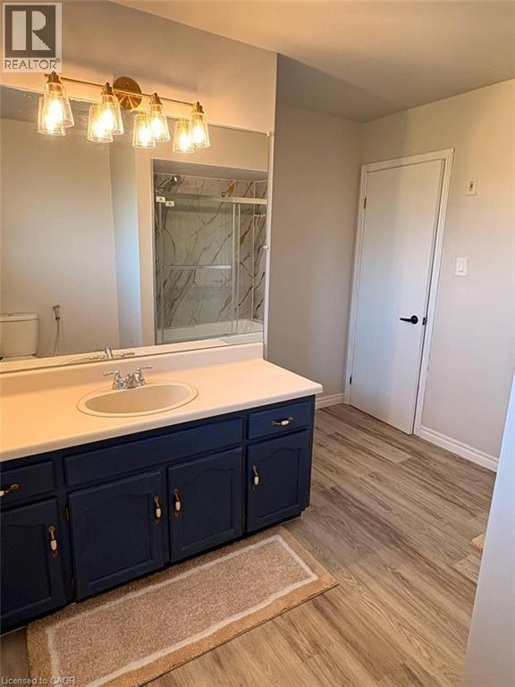 Bathroom featuring vanity, a marble finish shower, and light wood finished floors - 14 Windstar Place Unit# Upper, Hamilton, ON - Indoor Photo Showing Bathroom