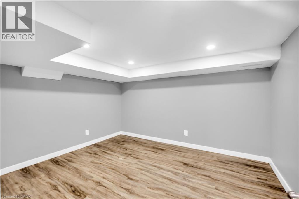 Finished below grade area featuring wood finished floors, baseboards, and recessed lighting - 129 Dundurn Street N, Hamilton, ON - Indoor Photo Showing Other Room