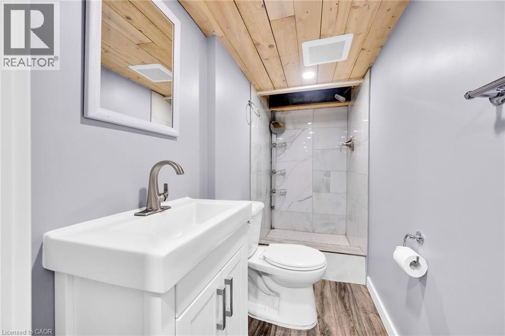 Bathroom with a shower stall, wood finished floors, wood ceiling, toilet, and vanity - 129 Dundurn Street N, Hamilton, ON - Indoor Photo Showing Bathroom