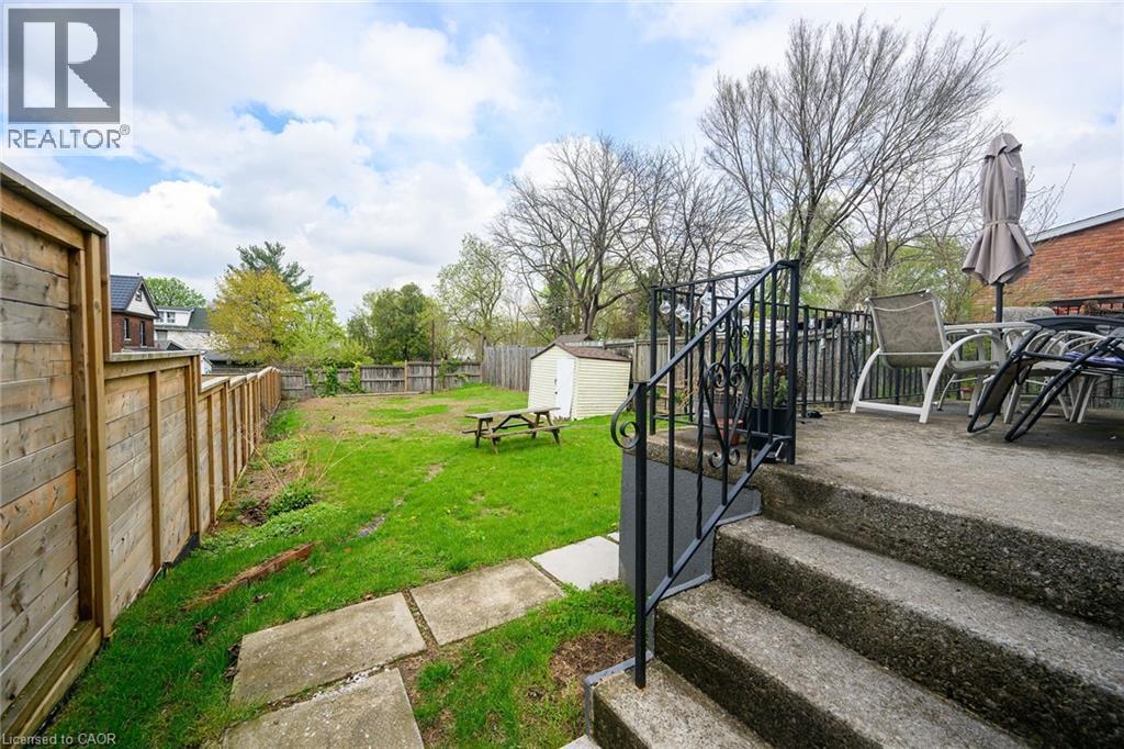 View of yard featuring a storage shed, an outdoor structure, and a patio area - 129 Dundurn Street N, Hamilton, ON - Outdoor