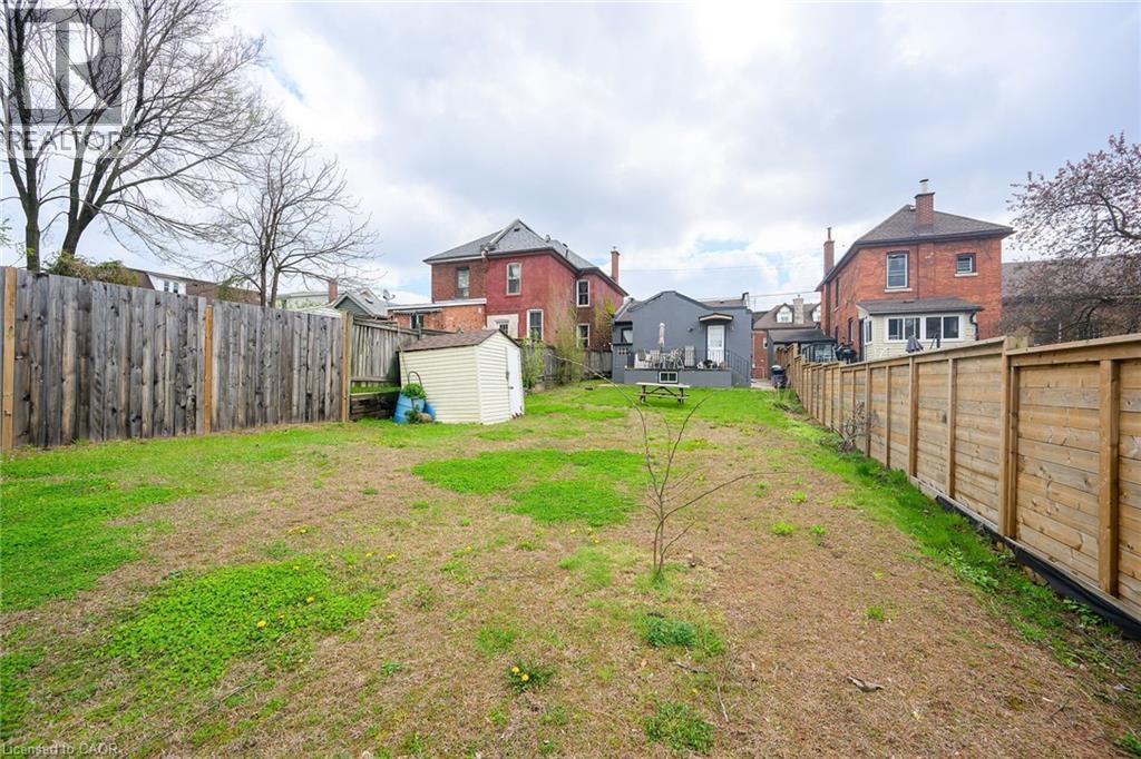 View of yard featuring a storage shed, an outbuilding, and a residential view - 129 Dundurn Street N, Hamilton, ON - Outdoor
