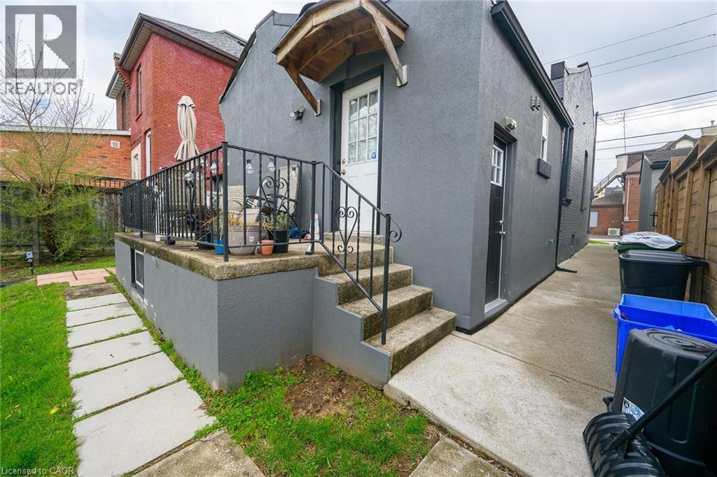 View of property exterior with stucco siding - 129 Dundurn Street N, Hamilton, ON - Outdoor With Exterior