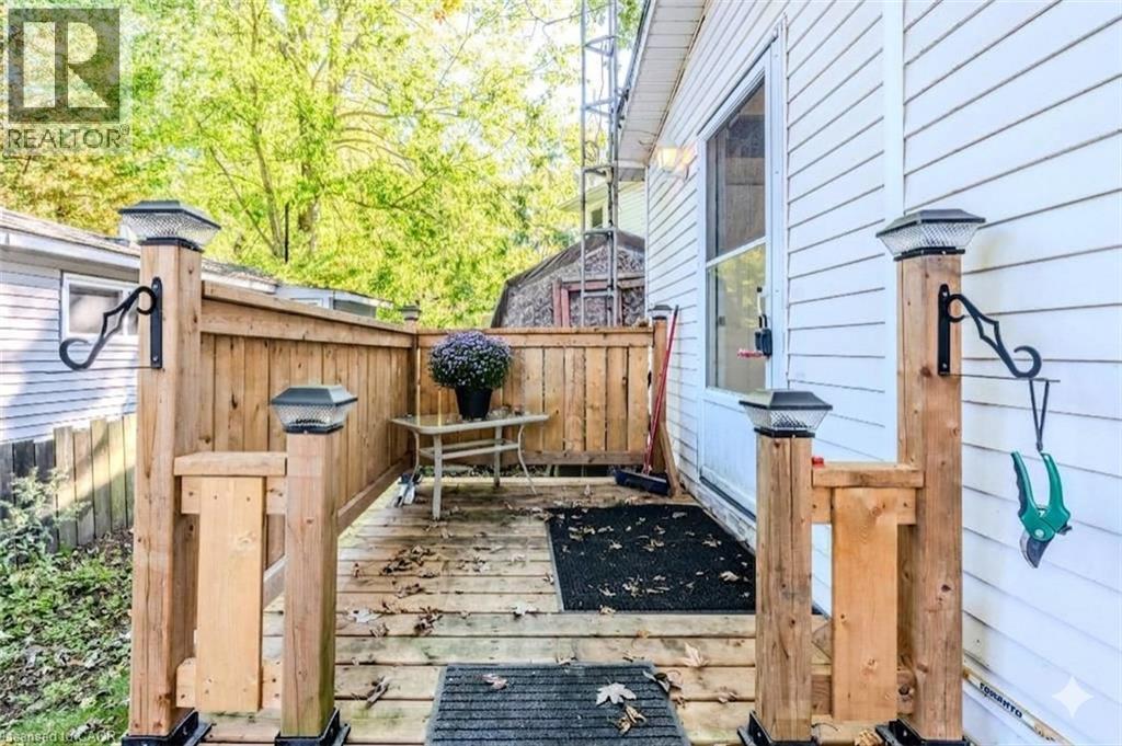Outdoor wooden deck with privacy fencing, featuring post cap lighting and white vinyl siding - 57 12Th Conc Road E Unit# 430, Flamborough, ON - Outdoor With Deck Patio Veranda