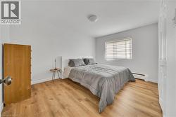 Bedroom with baseboard heating and light wood-type flooring -