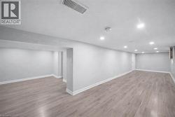Finished below grade area with light wood-style floors and recessed lighting -