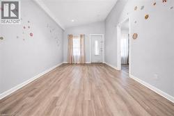 Empty room with lofted ceiling and light wood finished floors -